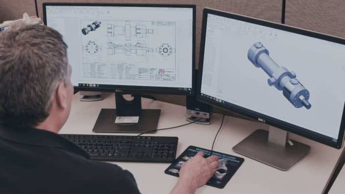 Engineer looking at Mill-Type Cylinder renderings on screen