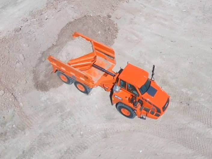 Orange Philippi-Hagenbuch loading gravel in Rear Eject Body